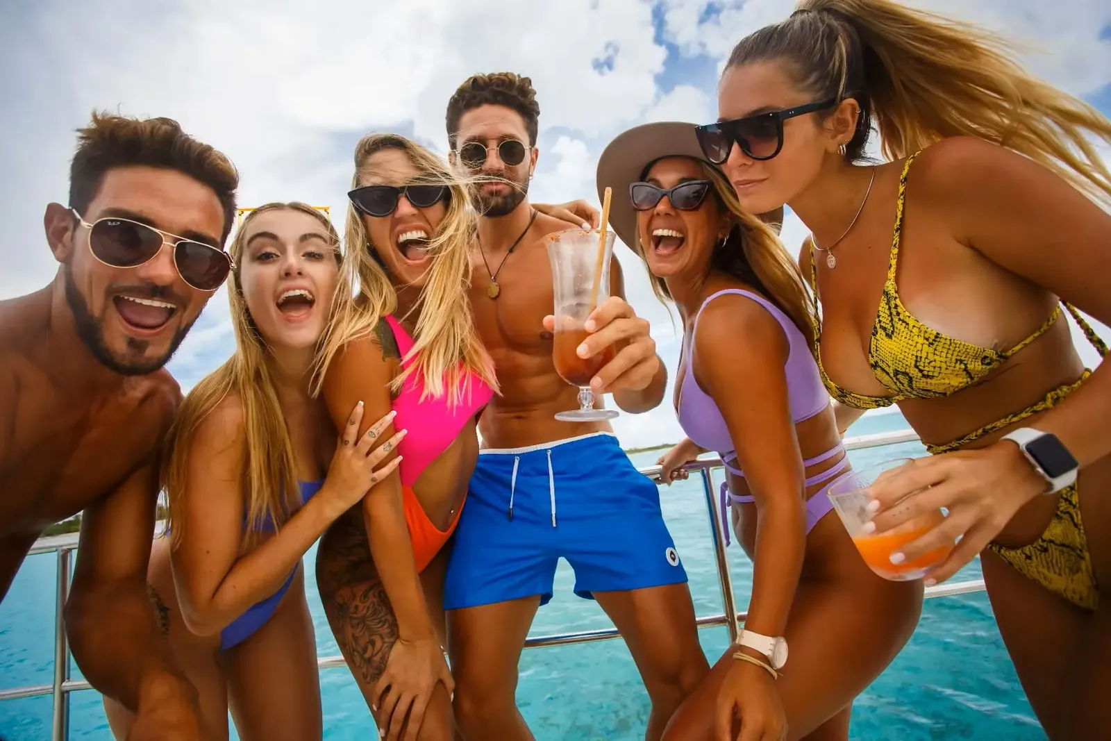 Group of friends celebrating with drinks on a boat cruise in Cancun